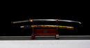 Katana Kohaku — Tamahagane, Poignée noire sur raie blanche, fourreau doré marbré, cordon noir.