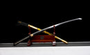 Katana Kohaku — Tamahagane, Poignée noire sur raie blanche, fourreau doré marbré, cordon noir.