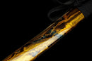 Katana Kohaku — Tamahagane, Poignée noire sur raie blanche, fourreau doré marbré, cordon noir.