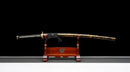Katana Akagane — Acier Damascus, Poignée : ito noir, garde dorée. Fourreau : noir laqué, motif doré