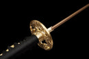 Katana Akagane — Acier Damascus, Poignée : ito noir, garde dorée. Fourreau : noir laqué, motif doré