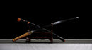 Katana Mikazuki — Acier Damascus, Poignée orange clair, ito noir, garde dorée ajourée, fourreau noir brillant.